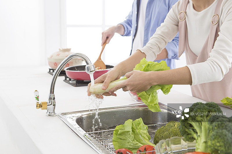 新婚夫妻在厨房烹饪图片素材