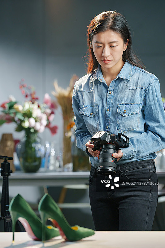 在工作室里拍照的青年女摄影师图片素材