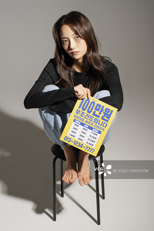 地上散落着贷款宣传单，一位20多岁的年轻人对获得贷款感到无助。图片素材