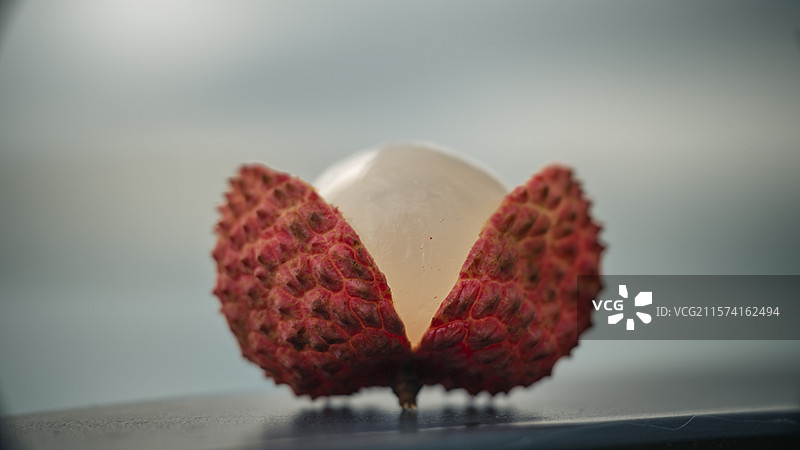草地上放着的桂味荔枝开口开果的特写镜头图片素材