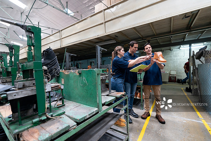 主管和员工检查靴子，指着它说话图片素材