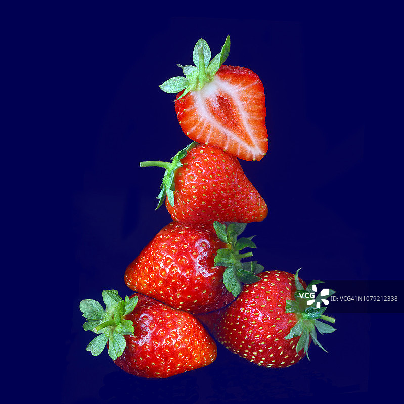 堆叠的成熟草莓，午夜蓝背景图片素材