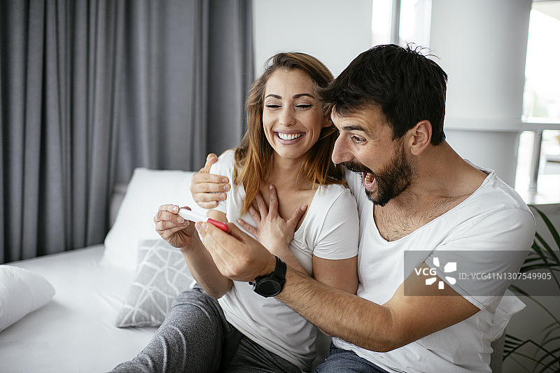 快乐情侣与怀孕喜讯的库存照片图片素材