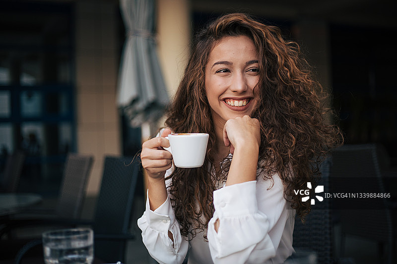 在咖啡馆里享受卡布奇诺的女人图片素材