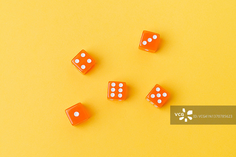 黄色背景上的五个橙色六面骰子图片素材
