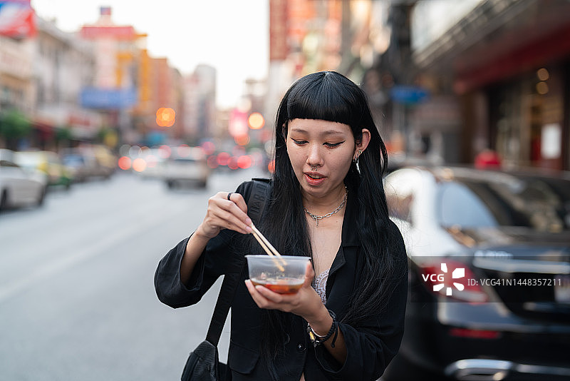 曼谷街头的年轻女子享用美食图片素材