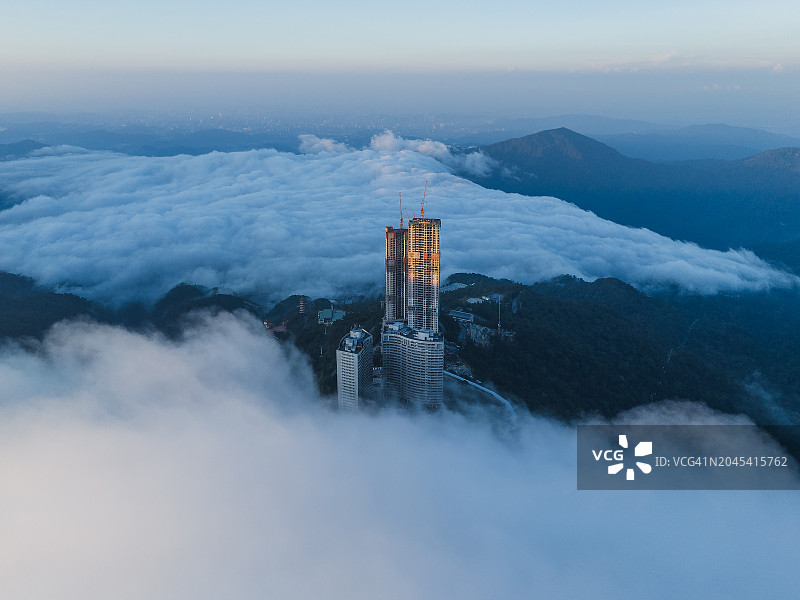 绿色雾中山间小镇与寺庙航拍全景，旅游景点和娱乐场所吸引游客图片素材