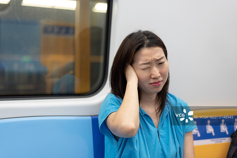 一位亚洲女性在旅行时耳朵感到疼痛图片素材
