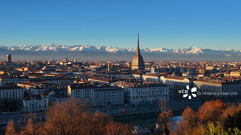 都灵城市景观，包含安东内利尖塔和日落时的阿尔卑斯山图片素材