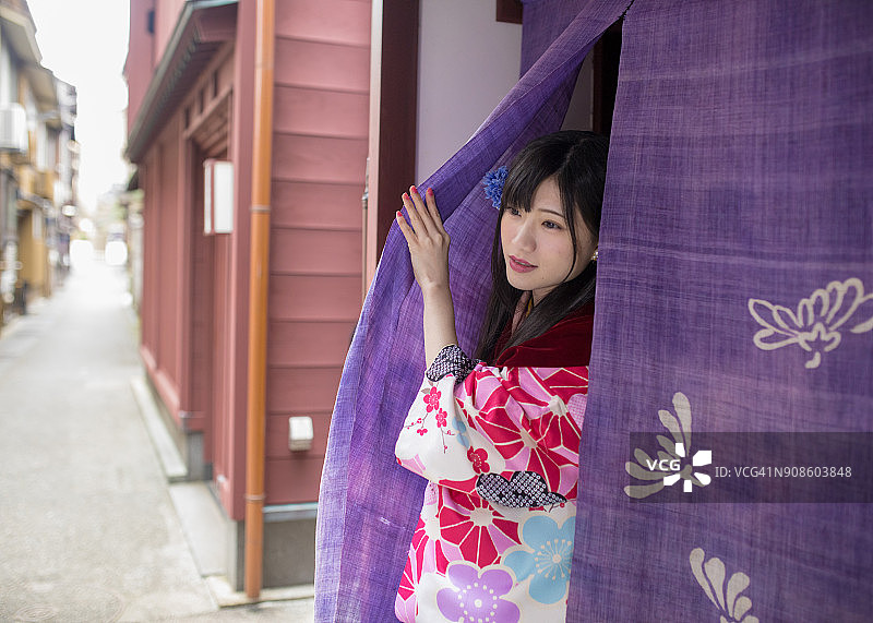 穿着和服从商店走出的美丽女人图片素材