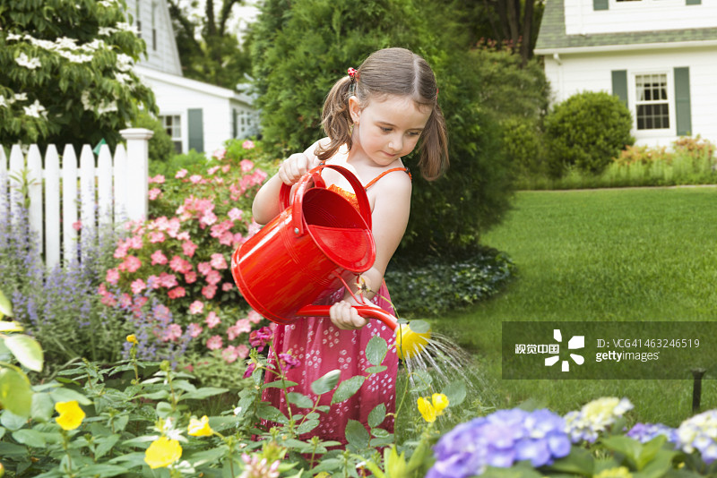 白人女孩在后院浇花图片素材